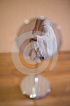 Reflection of the bride`s beige shoes in the mirror. Indoor