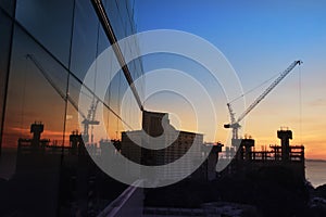 Reflection of building crane at sunset