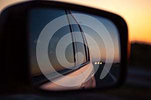 reflection in car rear mirror sunset on the road