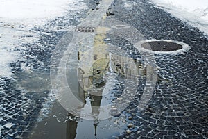 Reflection of church in puddle on the ground.