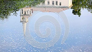The reflection of a church steeple on moving water