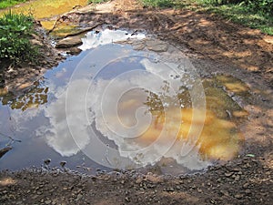REFLECTION OF CLOUDS IN POOLED WATER