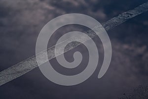 The reflection of the clouds and sky on the flood puddle on the road