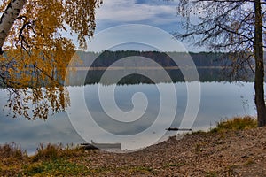 Reflection of the cloudy blue sky in the smooth water of the lake