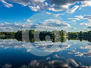 Reflection of the cloudy sky in the water of little lake