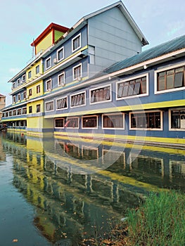 Reflection of a colorful building near an artificial lake