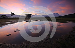 Reflection of colorful sunrise with Mount Kinabalu at the background