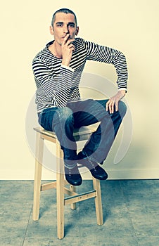 Reflection concept for man sitting on stool having doubts