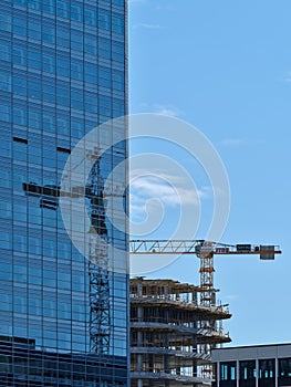 Reflection of a crane on the glass windows of the building