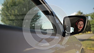 Reflection of cute girl in rearview mirror of car