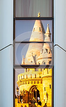 Reflection of Fisherman`s Bastion, aka Halaszbastya, fairy tale towers in modern hotel windows. Architectural contrast