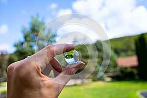 The reflection of a forest, mountains, sky in glass lens ball