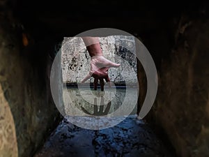 The reflection of a girl`s hand fellon a water-filled cistern