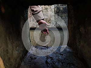 The reflection of a girl`s hand fellon a water-filled cistern