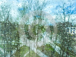 Reflection in glass, window of a multi-storey building. raindrops on the glass. texture, background. against the backdrop of trees