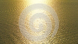 Reflection of Golden sunlight over sea surface texture background, the sun rises right above the sea beautiful ray is reflected