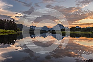 Reflection of Grand Tetons in Jackson Lake at sunset