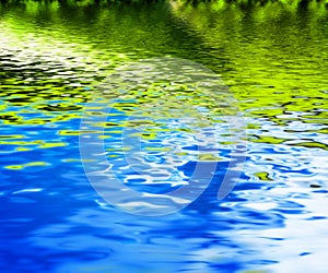 Reflection of green nature in clean water waves.