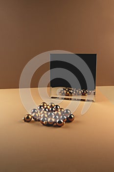 Reflection of group of christmas balls and shadow from balls in a mirror on beige surface
