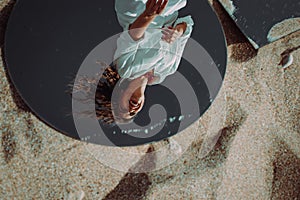 Reflection of happy laughing young woman. Mirror outdoor on sand. Enjoyment, happiness and freedom concept. Independent, carefree