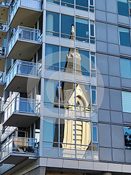 Reflection of a historical Gothic church in a modern apartment building in downtown Portland, Oregon, USA