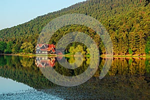 the reflection of a house on water surface of the lake