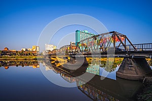 Reflection of Iron Bridge and colorful light lantern in sunrise. Loi Krathong or Yi Peng Festival in Chiang Mai, Thailand