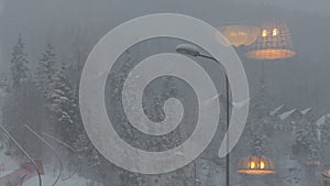 Reflection of the lamp in the window during snow weater.