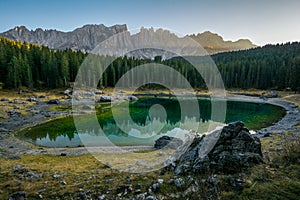 Reflection of Latemar in the clear water of Lake Carezza Karersee in Dolomite Alps, Trentino Alto Adige, South Tirol, Italy