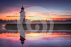 Reflection of Leuchtturm historical landmark and cultural property in Moritzburg, Germany at sunset