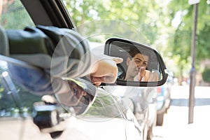 Reflection of Man Pointing in Side View Car Mirror