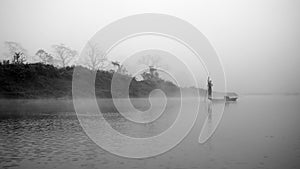 Reflection: man rowing on the boat in the foggy