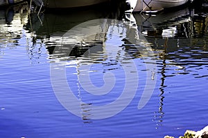 Reflection in the Mediterranean Sea surface of white yachts