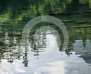 Reflection in the mountain lake of coniferous forest and mountain landscape