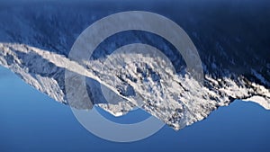 Reflection of mountain peaks in water of Lower Multinskoe lake in the Altai Mountains