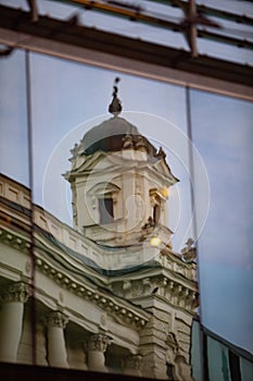reflection of old building in glass window
