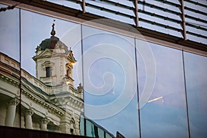 reflection of old building in glass window