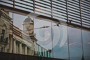reflection of old building in glass window