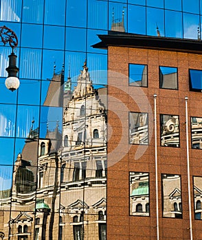 Reflection of an old building in new glass building. Old architecture versus modern reflected in glass. City of Liberec