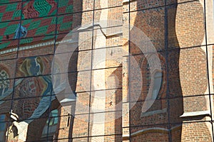 Reflection of an old, Gothic church with a multi-color roof