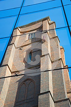 Reflection of an old, Gothic church with a multi-color roof