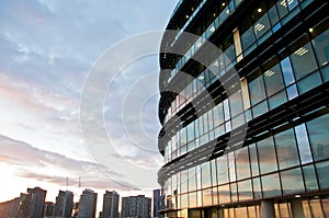 Reflection of pastel Sun set on window glass of modern corporate office building