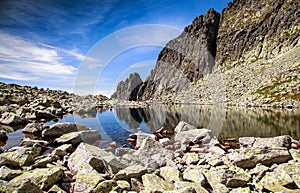 Reflection of peaks in mountains. Tarn - Wahlenbergovo pleso in High Tatras at Slovakia