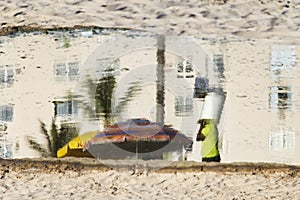 Reflection of a person in the puddle of water at Ondina beach