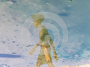 Reflection of a person in the puddle of water at Ondina beach
