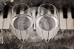 Reflection of piano keys in two wine glasses, pianoforte photo