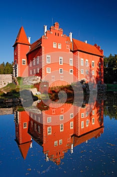 Reflection of the red castle on the lake, with dark blue sky, state castle Cervena Lhota, Czech republic photo