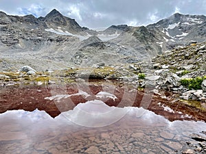 Reflection in a red lake in Lower Engadine, Grisons, Switzerland