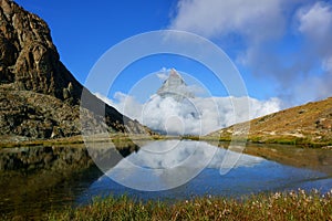 Reflection in the Riffelsee of Matterhorn and cloud under with l