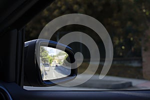 Reflection of the road in the car side rear-view mirror